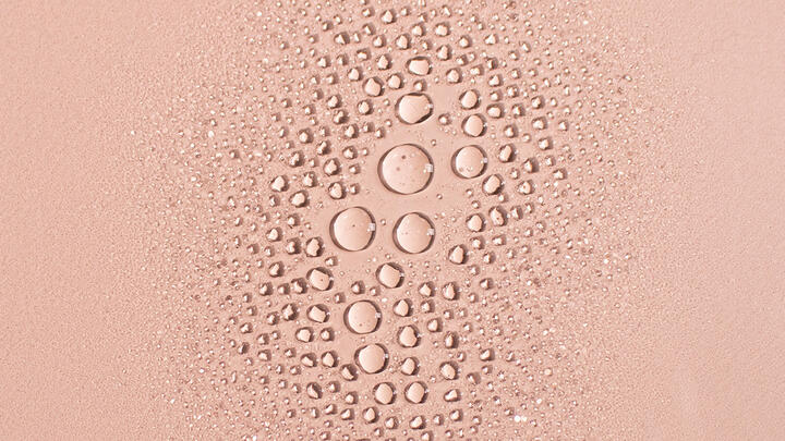 Cluster of mist droplets on a peach colored background